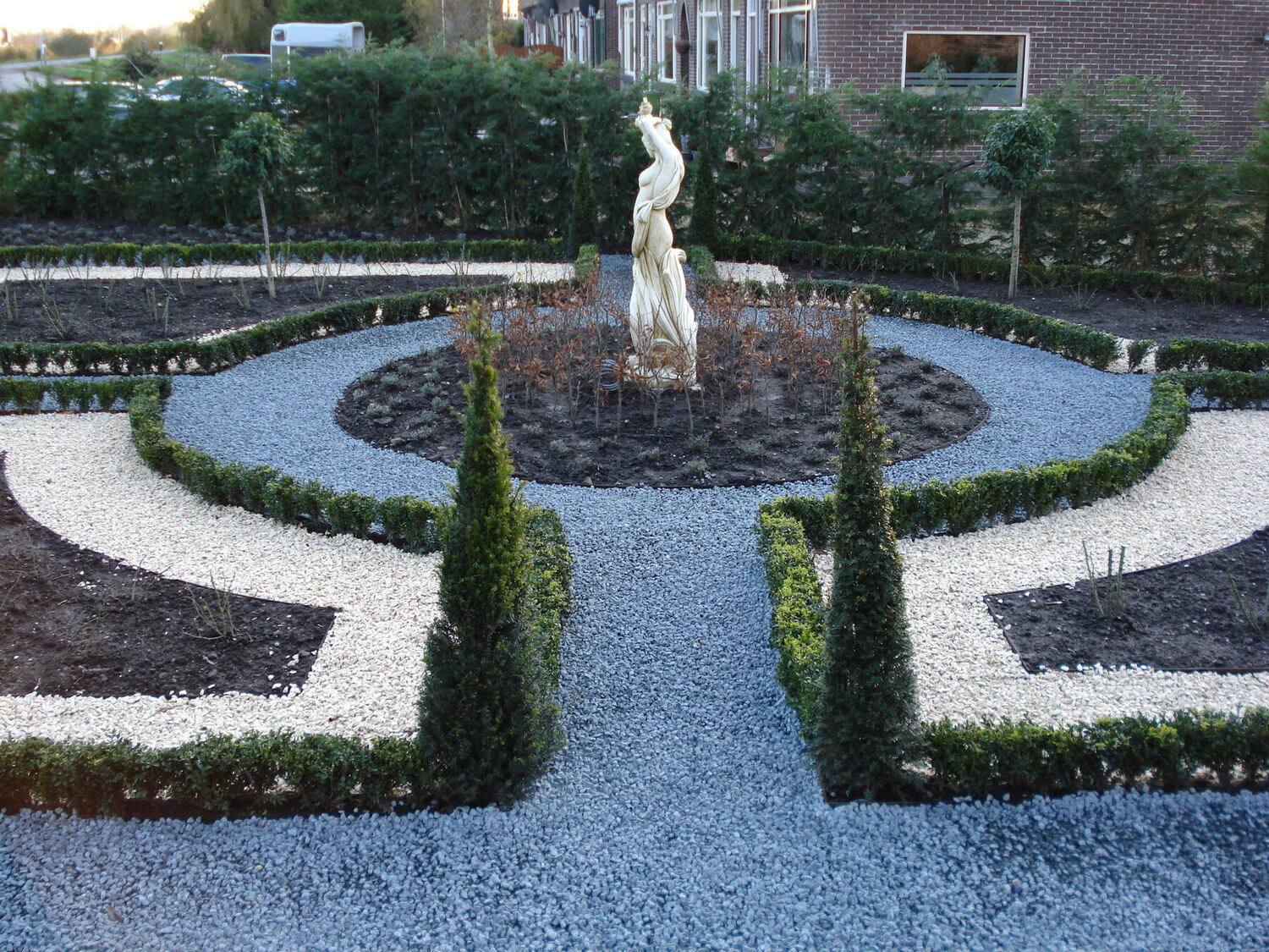 Klassieke tuin met beeld, buxushagen en grindpaden