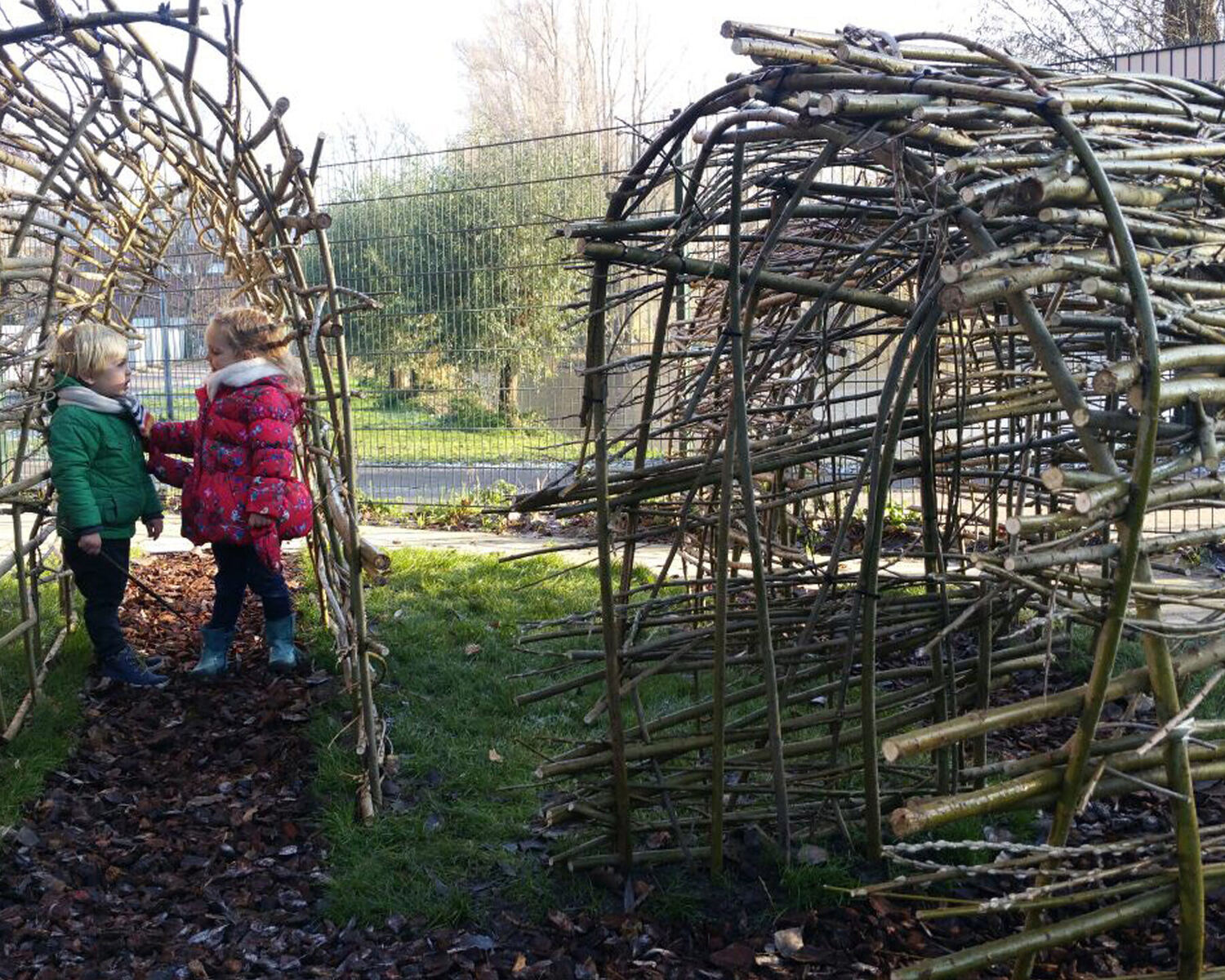 Kinderen in een wilgentunnel op een natuurlijke speelplek